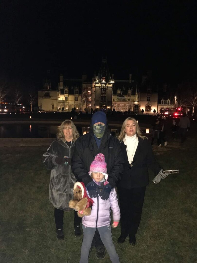 A family posing for the camera in front of an old castle.