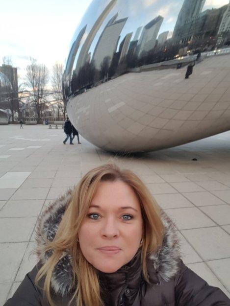 A woman taking a selfie in front of an airplane.