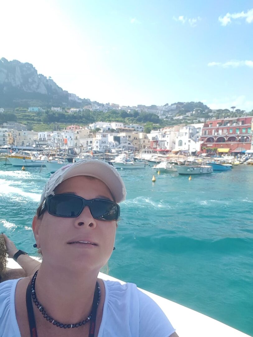 A man in sunglasses and a hat is on the water.