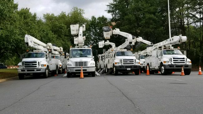 A group of trucks parked in the street next to each other.